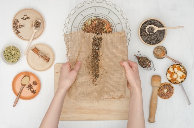 Woman's hands preparing Indian masala tea with spices