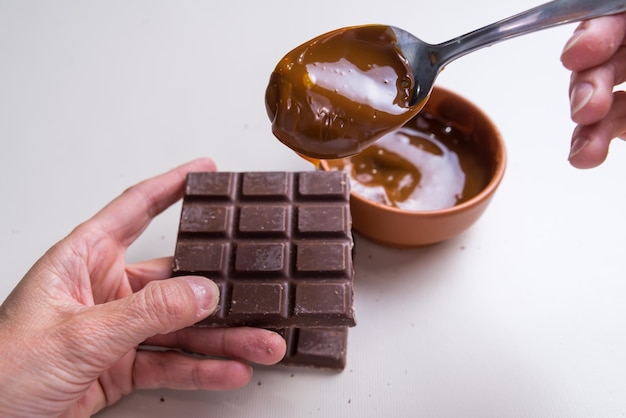 Woman's hands putting dulce de leche on a chocolate not suitable for diabeticsxA