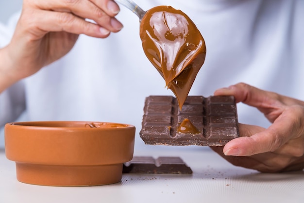 Woman's hands putting dulce de leche on a chocolate not suitable for diabeticsxA