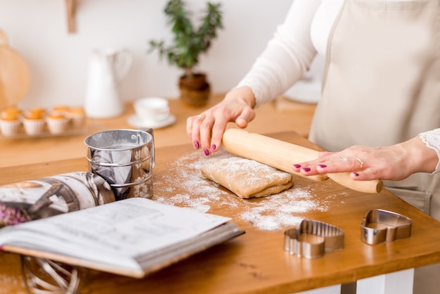 Woman's hands roll the dough. Protection Symbol, heat comfort.