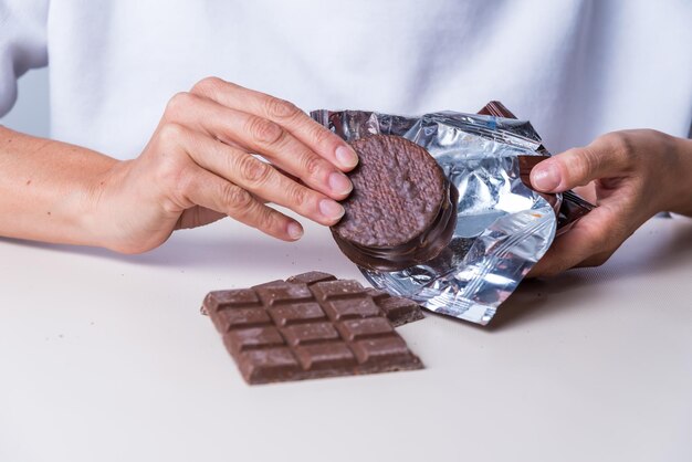 Woman's hands with a chocolate alfajorxA