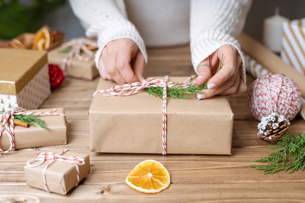 Woman s hands wrapping Christmas gift, close up.