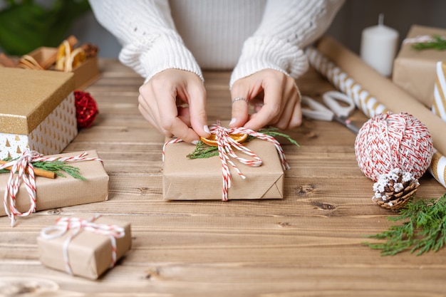 Woman s hands wrapping Christmas gift.