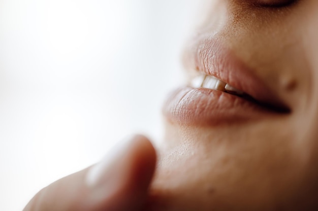 A woman's lips are shown with a finger pointing to the right.