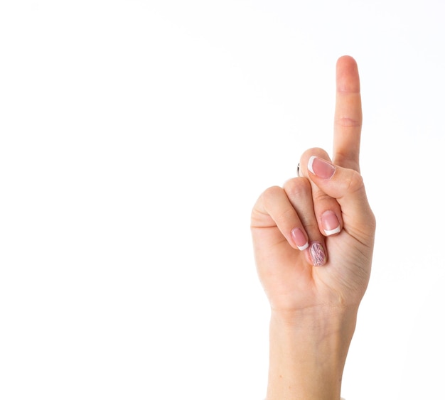 Woman's white hand showing forefinger up on white background in studio