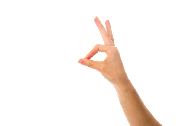 Woman's white hand showing okay on white background in studio