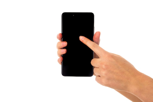 Woman's young hand holding a smartphone and touching it on white background in studio