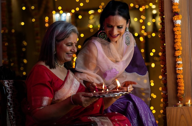 Photo a woman in a sari is holding a plate with a candle