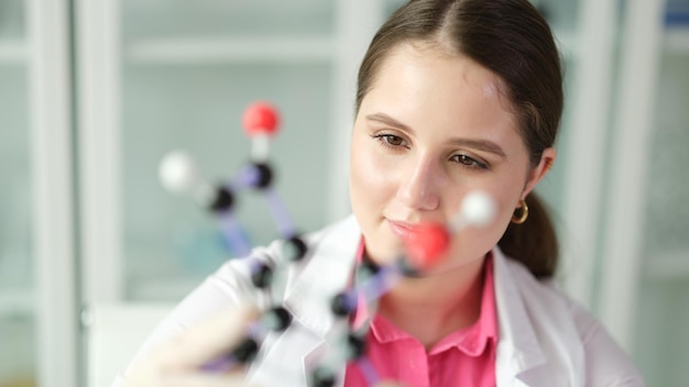 Woman scientist chemist studying molecule structure on plastic d model