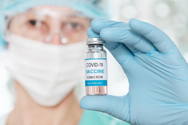 Woman scientist holding a vial with coronavirus vaccine covid  omicron variant