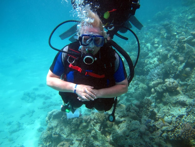 Woman scuba diver and beautiful colorful coral reef underwater.