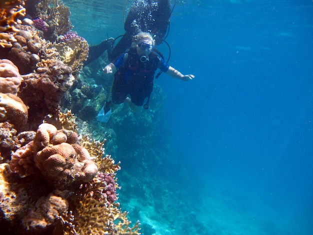 Woman scuba diver and beautiful colorful coral reef underwater.