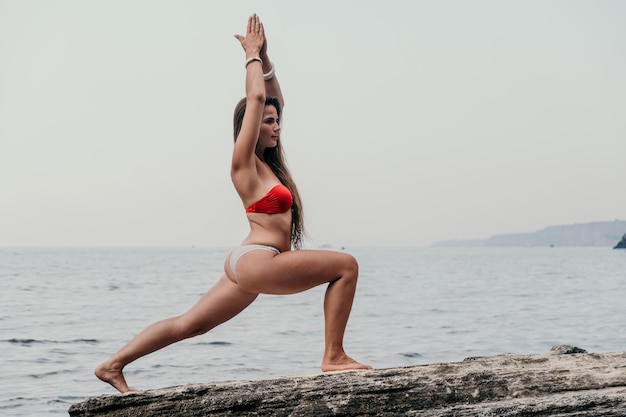 Woman sea yoga back view of free calm bliss satisfied woman with long hair standing on top rock with