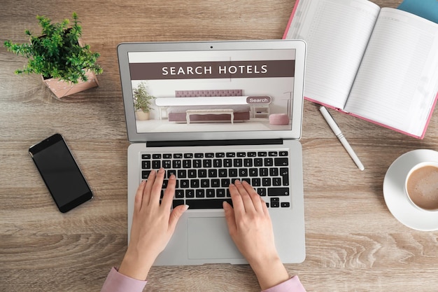 Woman searching hotel using laptop at table top view Booking online service