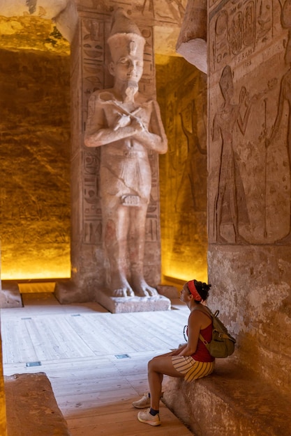 A woman seated inside an Egyptian temple