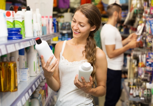 Woman selecting shampoo in store 