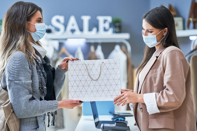 Woman seller and buyer in clothes store. High quality photo