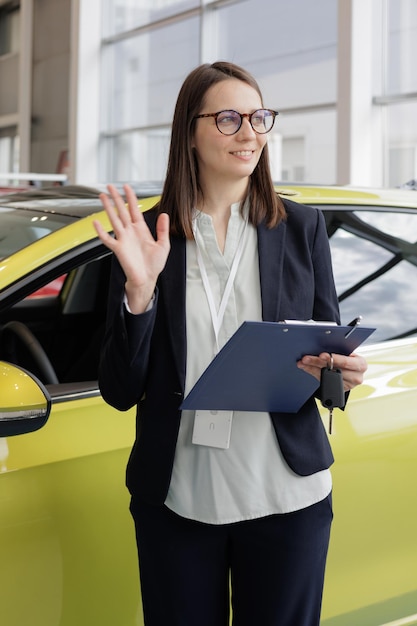 Woman sells a car at a car dealership and hands over the keys to the buyer nice woman car sales manager