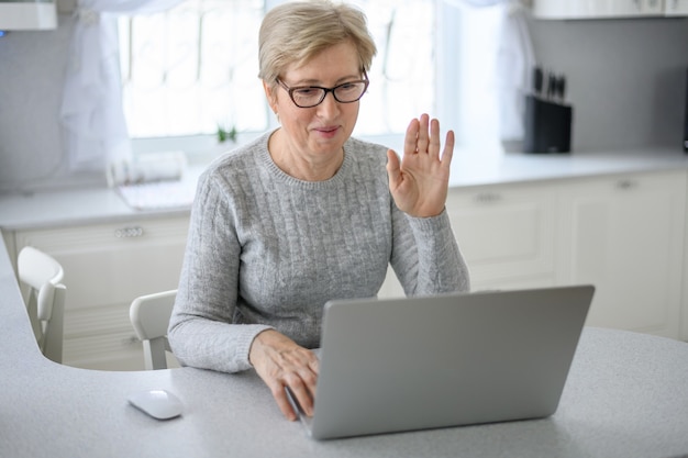 A woman senior work at home using modern technology in everyday life.