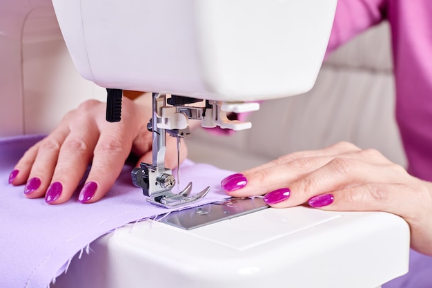 Woman sewing a dress on a sewing machine