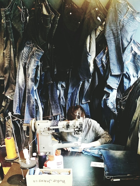 Photo woman sewing jeans in factory