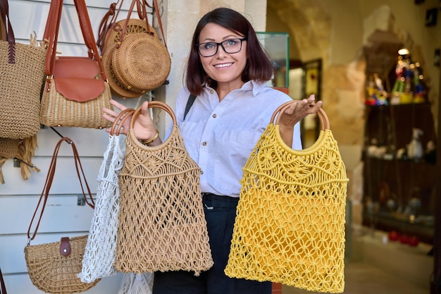 Woman shopper buying a trendy woven eco bag in the store