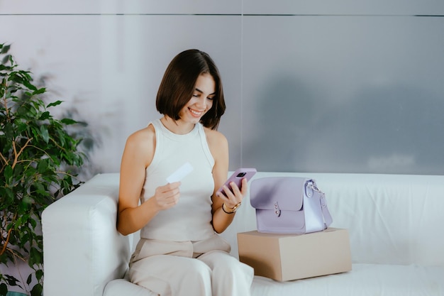 Woman shopping online for products with a card in hands