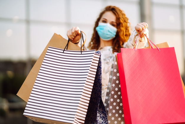 Woman in shopping. Young girl in protective sterile medical mask on her face.