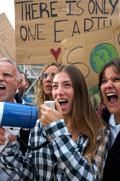 Photo woman shouting megaphone at protest against pollution of planet group diverse people demonstration