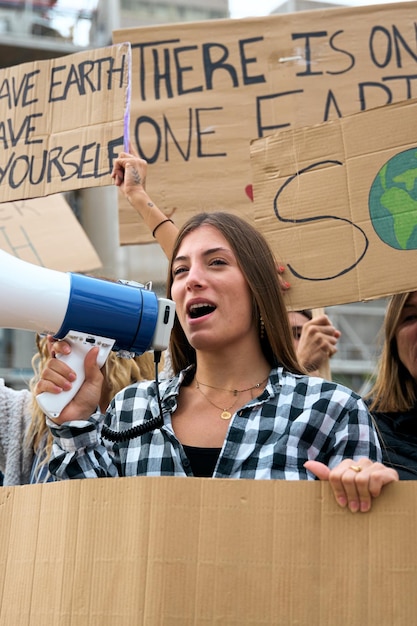 Photo woman shouting with a megaphone in a demonstration people at manifestation on climate change