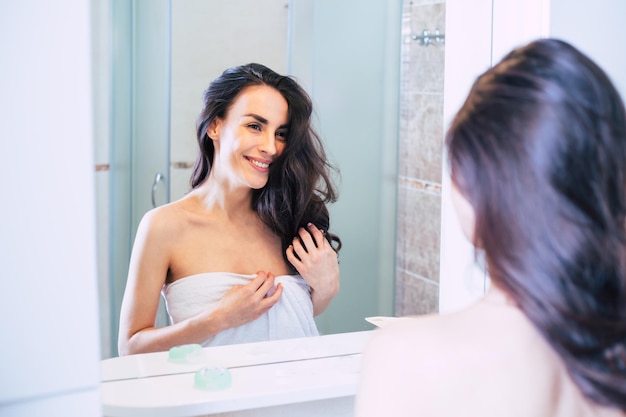 Woman in the shower Beautiful smiling girl getting ready to take a shower