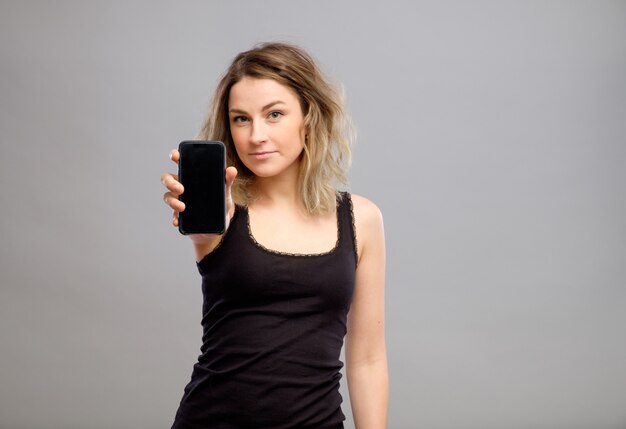 Woman showing blank smartphone screen