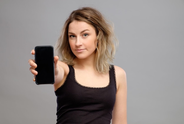 Woman showing blank smartphone screen