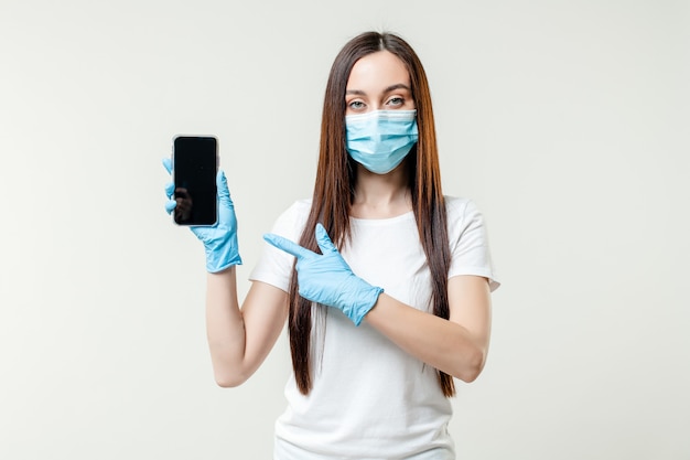 Woman showing empty copy space phone screen wearing mask and gloves