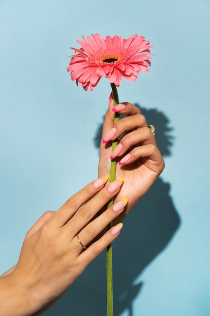 Woman showing her nail art on fingernails with flower