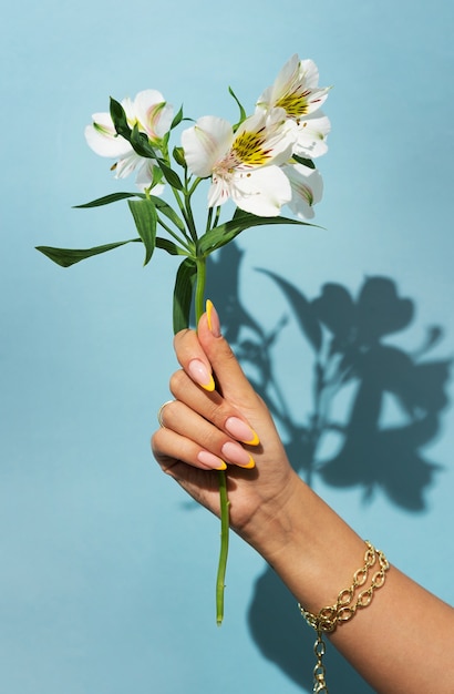 Woman showing her nail art on fingernails with flower