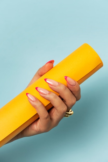 Woman showing her nail art on fingernails with paper roll