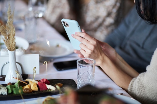 Woman showing some pictures from her smartphone to her friends