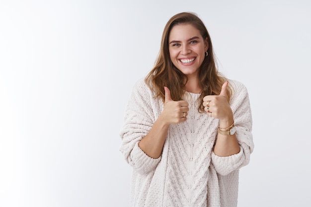 woman showing thumbs up smiling broadly happy giving approval gesture agree