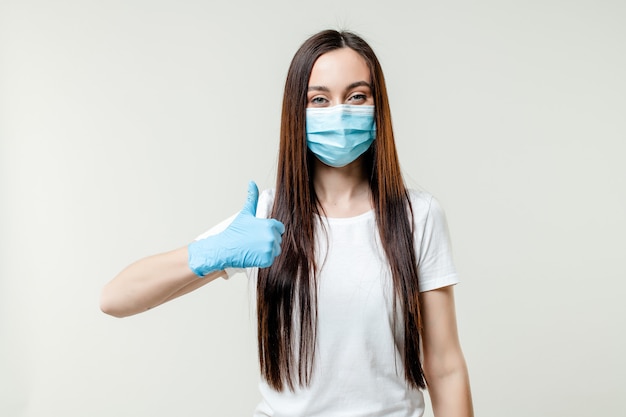 Woman showing thumbs up wearing mask and gloves