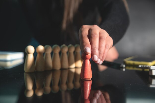 Photo woman showing wooden human figures recruitment leadership