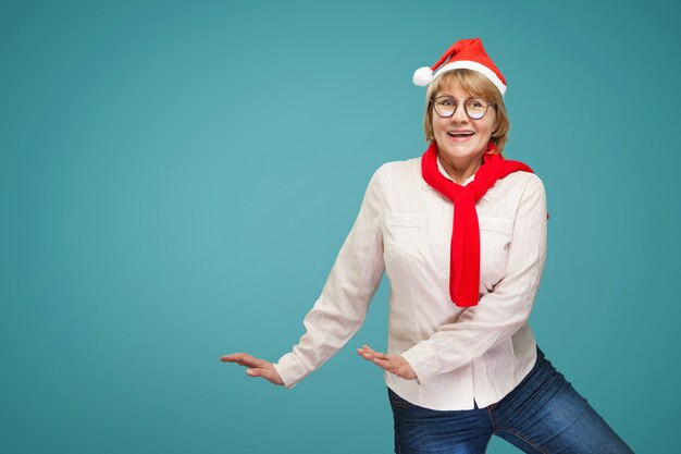 Woman shows dance. A middle-aged woman in the new year and Christmas clothes on a blue background