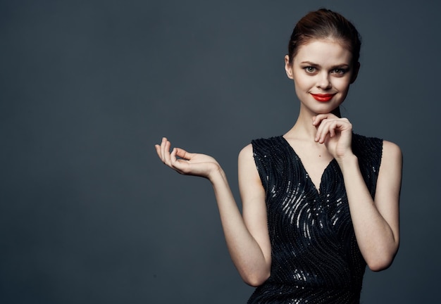 Woman shows her hands to the side on a gray background emotions advertising model