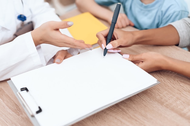 A woman signs documents at the hospital.