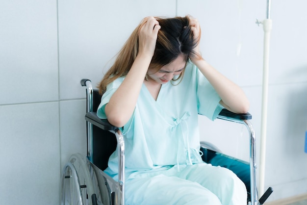 A woman sit on a wheelchair at hospital Sick and stressed