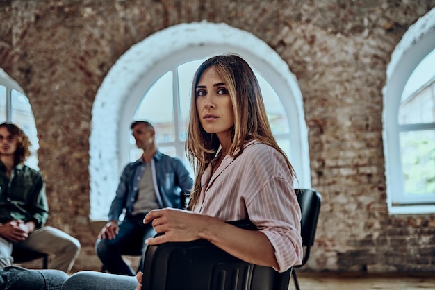 woman sits in circle at group psychological counseling relieved undergo treatment at therapy session