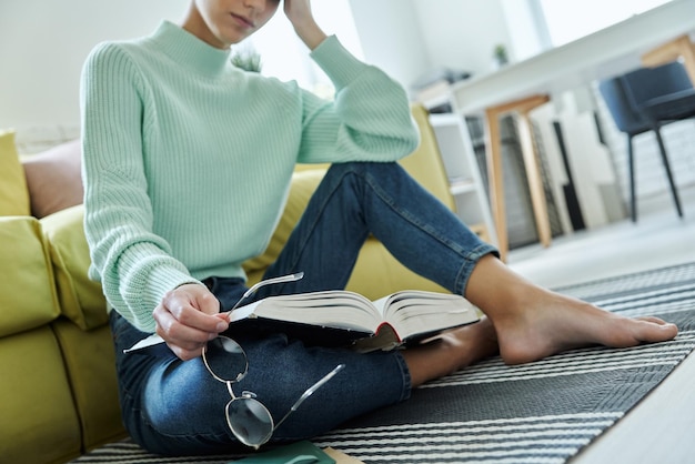 a woman sits on a couch and reads a book