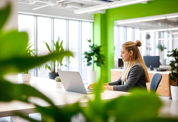 Photo a woman sits at a desk with a laptop and a plant in the background