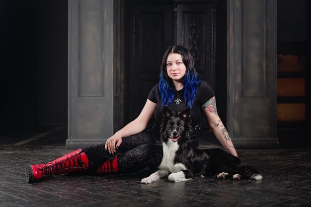 A woman sits on the floor with a dog.