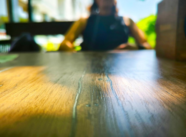 a woman sits at a table with a cup of coffee and background table